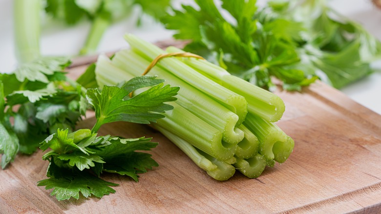 bundle of celery sticks on chopping board
