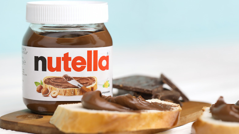 Nutella jar alongside bread slices covered with the spread