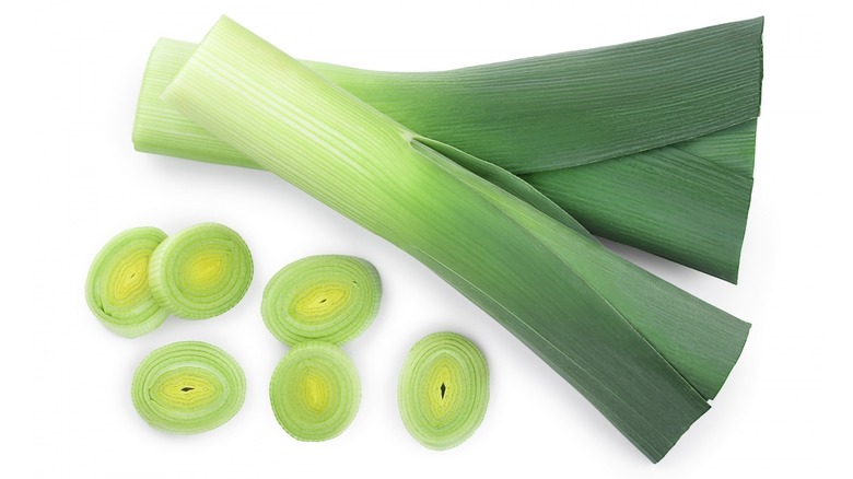 whole and sliced leek on white background