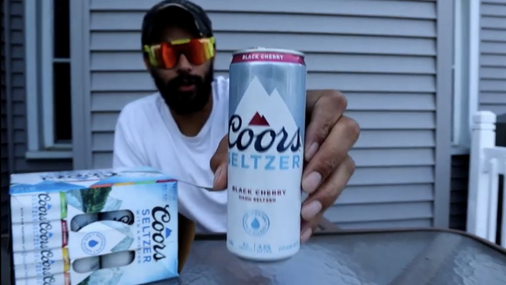 YouTube reviewer holding up can of Coors Seltzer