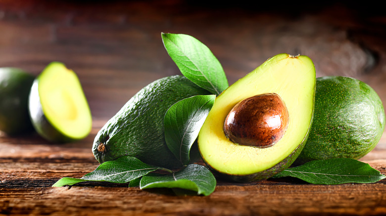 Avocados on a brown table. 