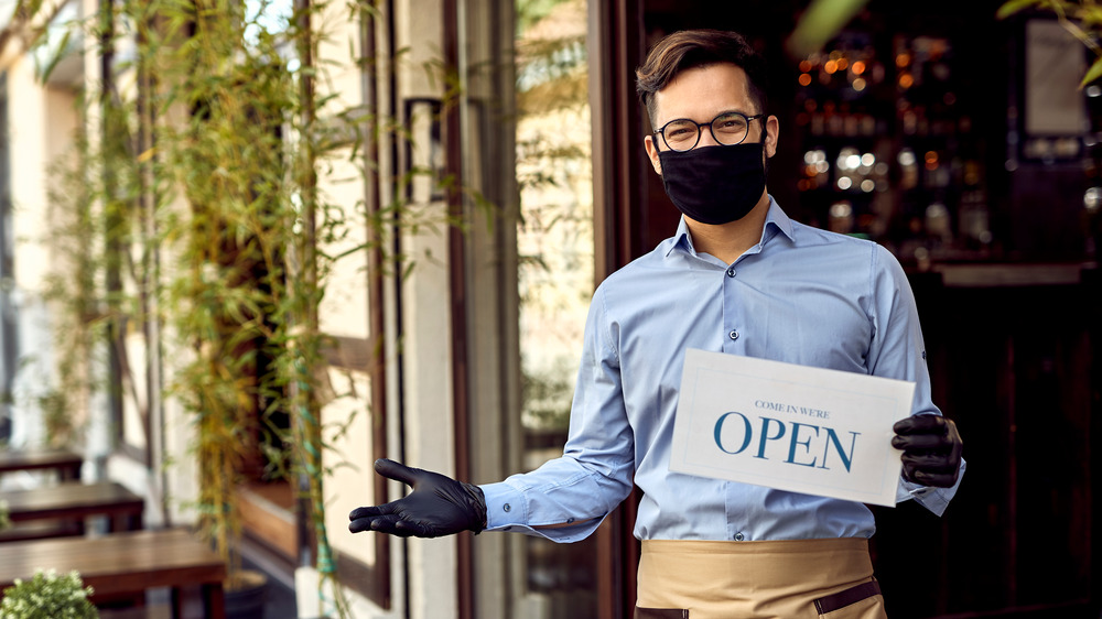 Masked server at outdoor restaurant