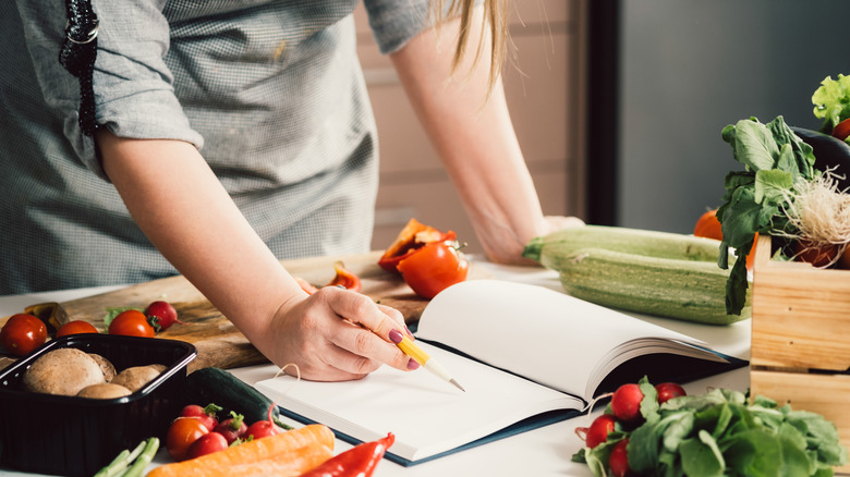 woman cooking from cookbook