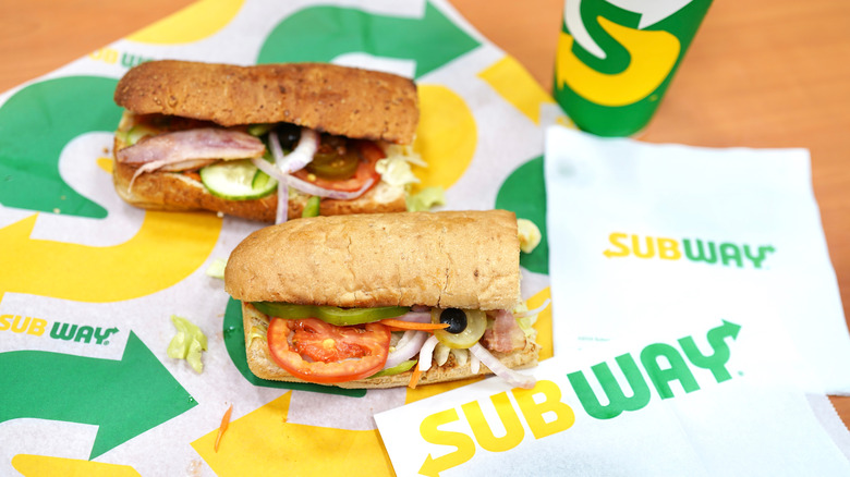 two Subway subs, a drink, and napkins