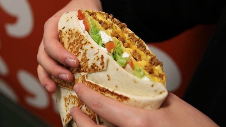 A Taco Bell Granda Crunchwrap in hand