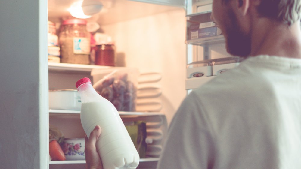 guy putting milk in freezer