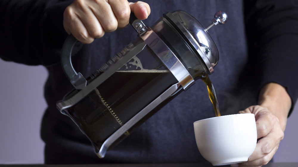 person pouring coffee from a French press