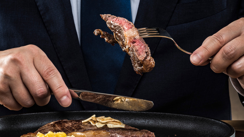 man eating steak