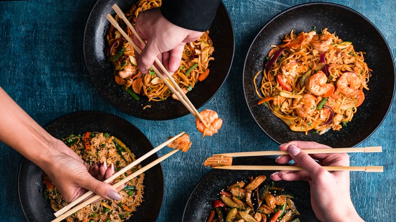 People using chopsticks at a table