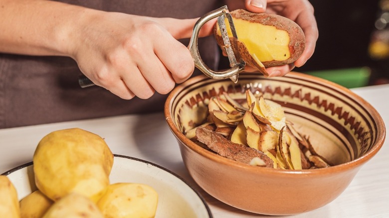 A person peeling potatoes 