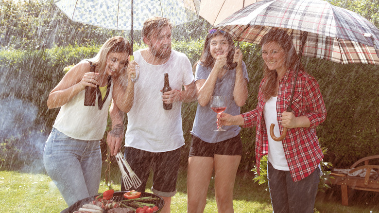 People grilling in the rain
