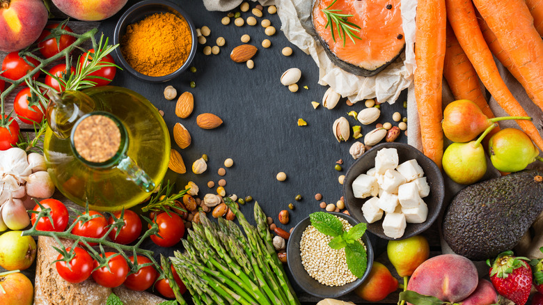 Array of Mediterranean food items including carrots, feta cheese, tomato, almonds, avocado, and asparagus