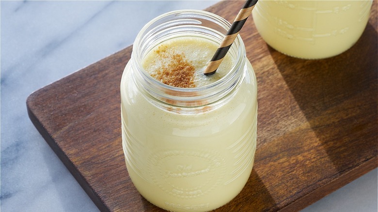 Eggnog in glass jar with straw