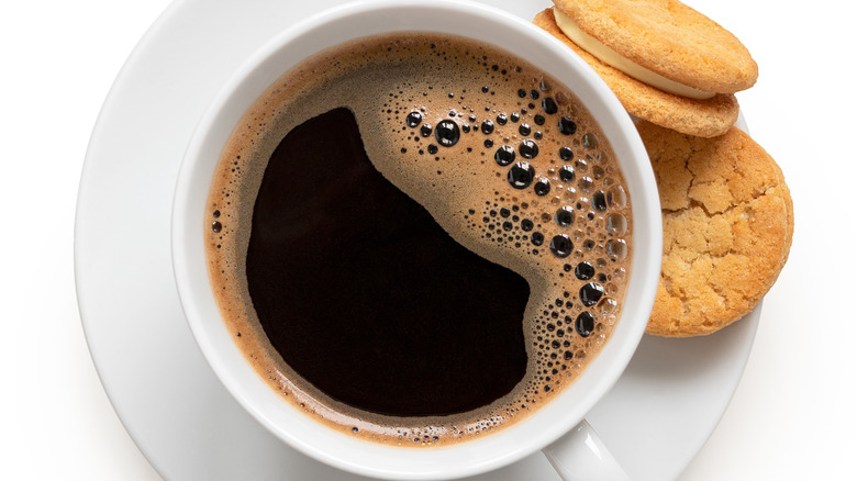 bubbling black coffee with cream biscuits
