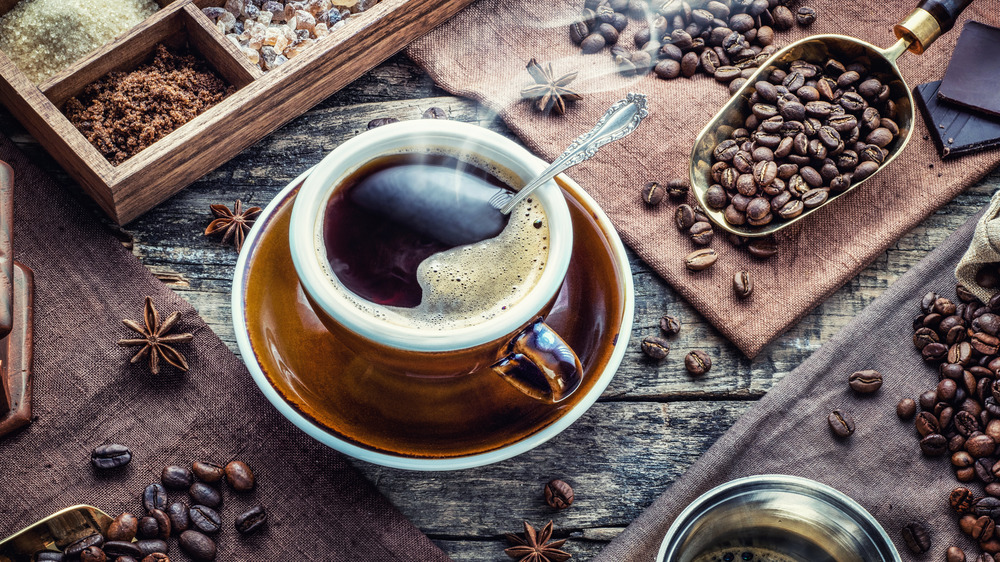 Cup of coffee with beans and spices