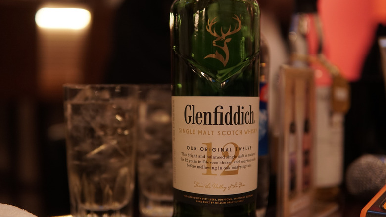 Bottle of Glenfiddich 12 with glassware blurred in background
