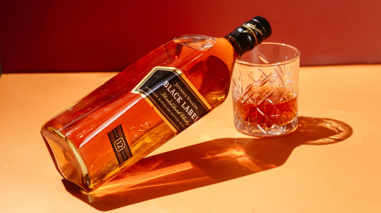 Bottle of Johnnie Walker Black Label resting on a glass of whiskey