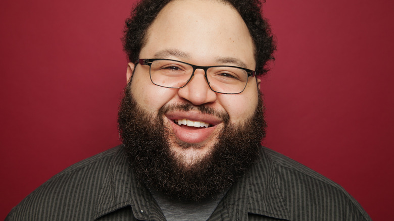 Zach Cherry headshot with red background 