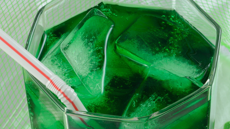   Bebida verde en vaso con hielo