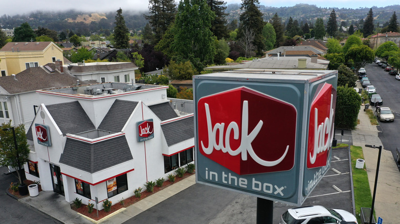 Jack in the Box sign and building against backdrop of trees