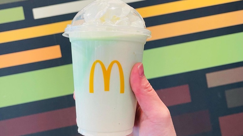 person holding McDonald's shamrock shake