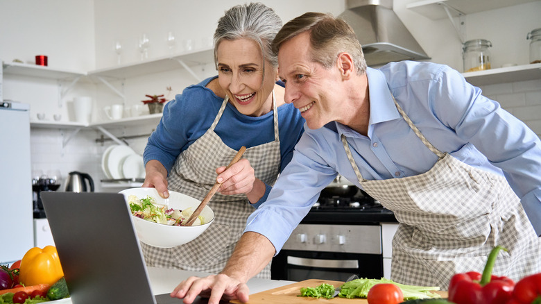 couple cooking with recipe