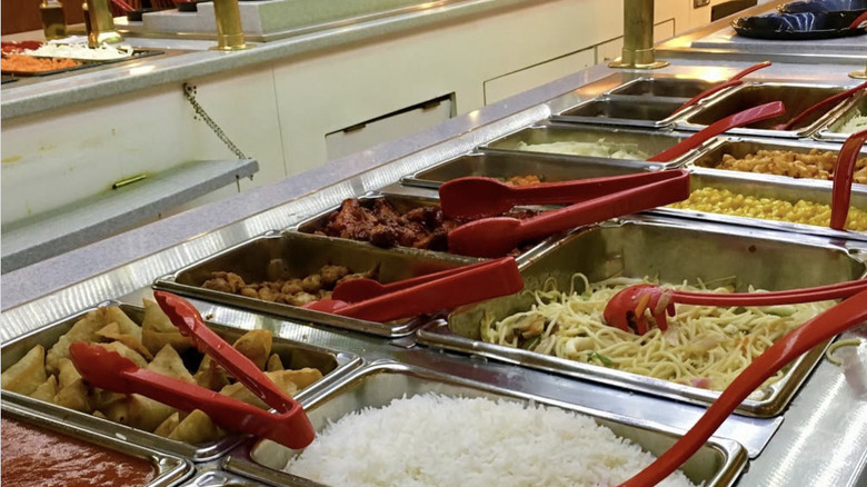 Buffet hot table with spaghetti and red utensils
