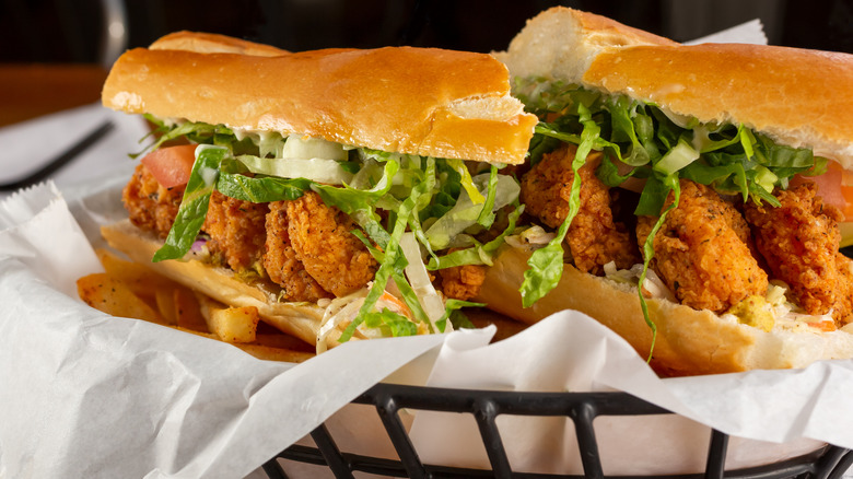 Fried shrimp po' boy in black basket with white paper