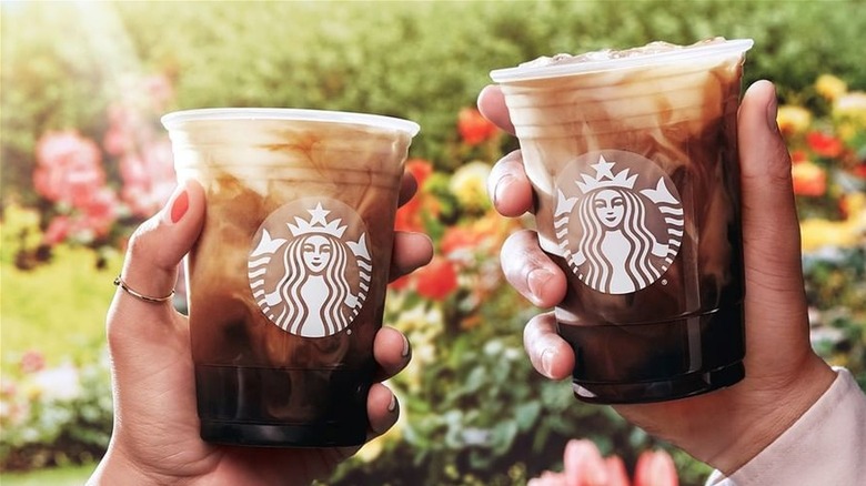 Iced Starbucks coffee with milk being held