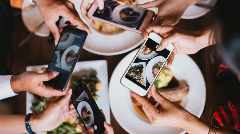 group people taking photos of their food