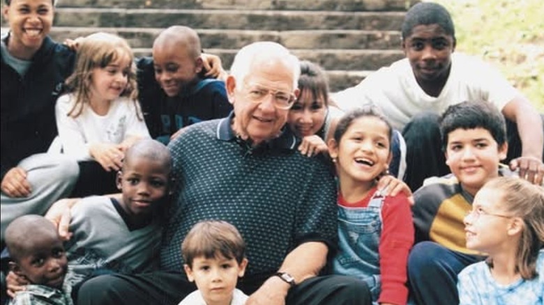 Dave Thomas sits with several adopted children.