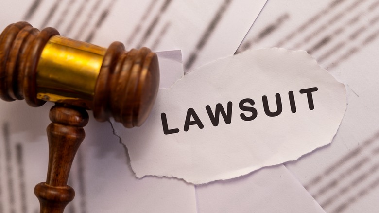 Gavel sits on a torn paper that says "lawsuit."