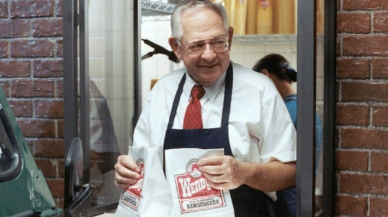 Dave Thomas hands out Wendy's orders from a drive-through window.
