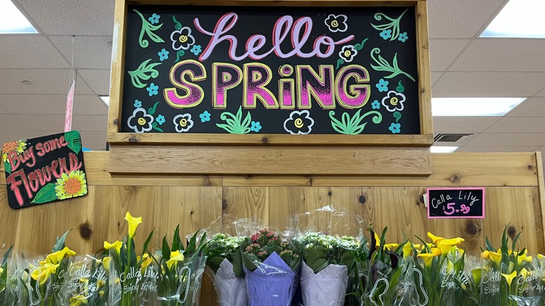 A display of spring flowers with chalk signage at Trader Joe's.