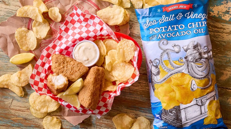 A bag of salt and vinegar chips on table next to fried appetizers in a basket.