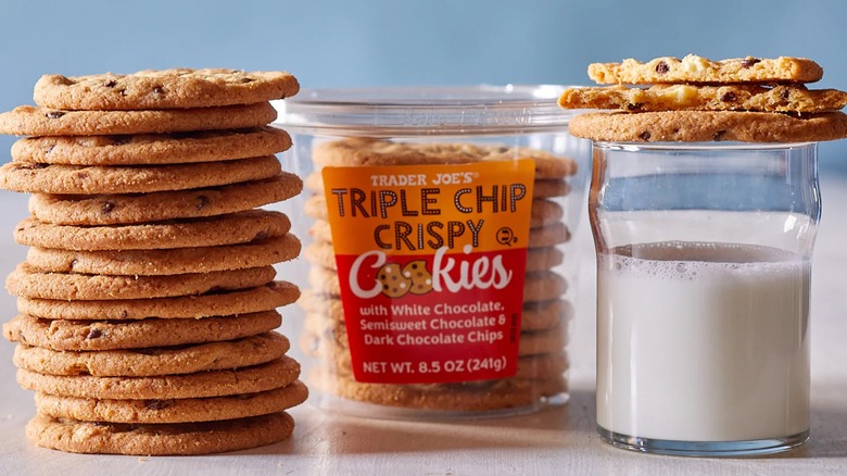 Container of triple chip crispy cookies with glass of milk.
