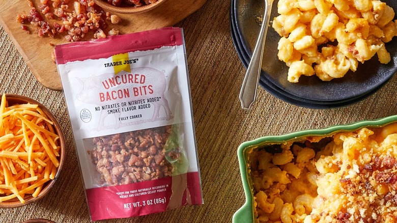 Bag of uncured bacon bits surrounded by mac and cheese and ingredients.