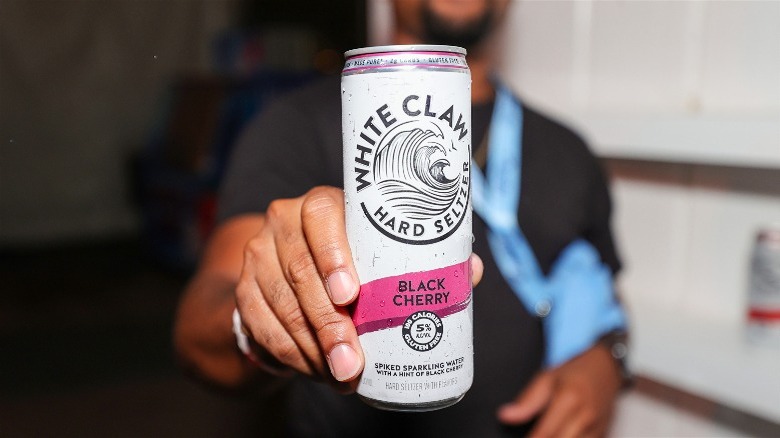 Person holding a can of black cherry White Claw hard seltzer