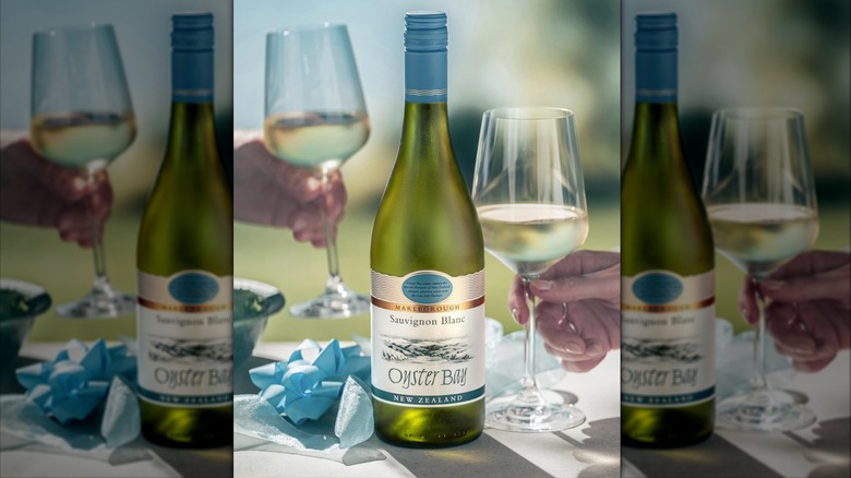 Bottle of Oyster Bay white wine with glasses in the background.