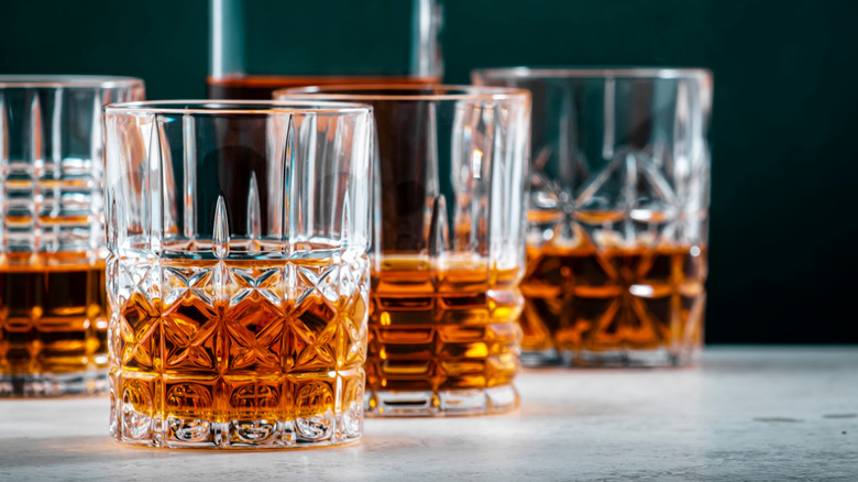Glasses of whiskey with bottle in background