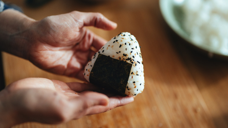 hands holding onigiri rice ball