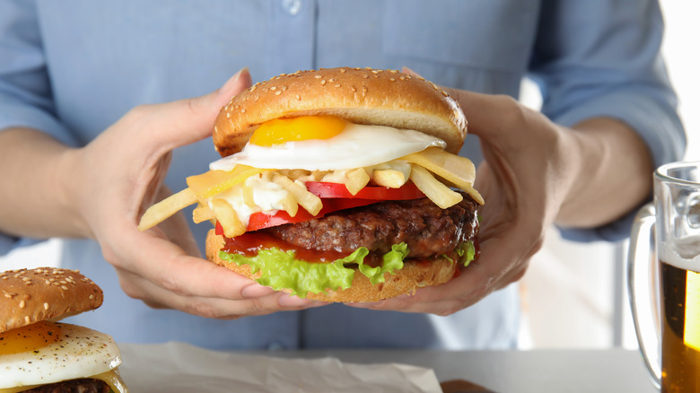 person holding messy burger
