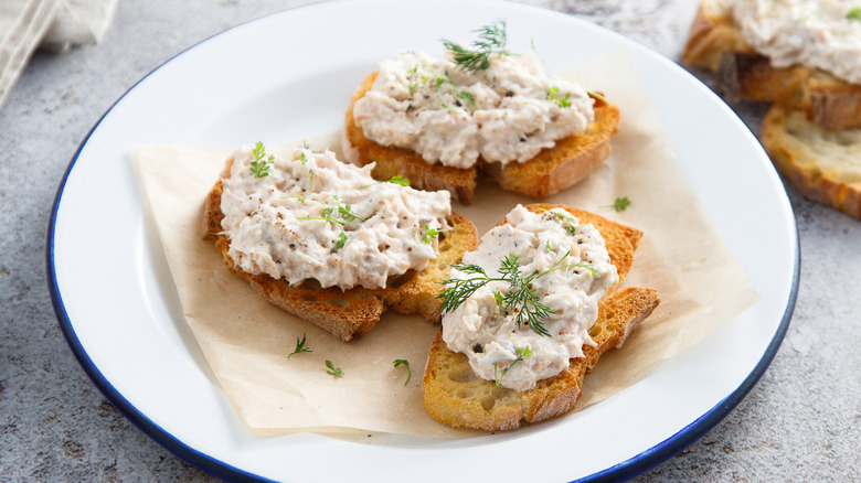 bread with smoked salmon spread on a white plate