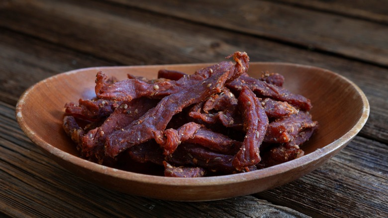 bowl of beef jerky on a dark wood table