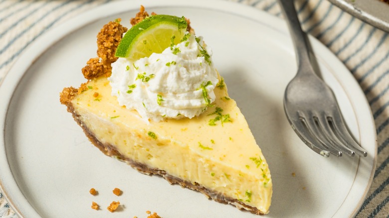 slice of key lime pie on a plate with a fork next to it