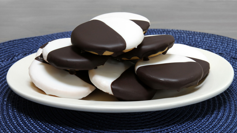 black and white cookies stacked high on a white plate