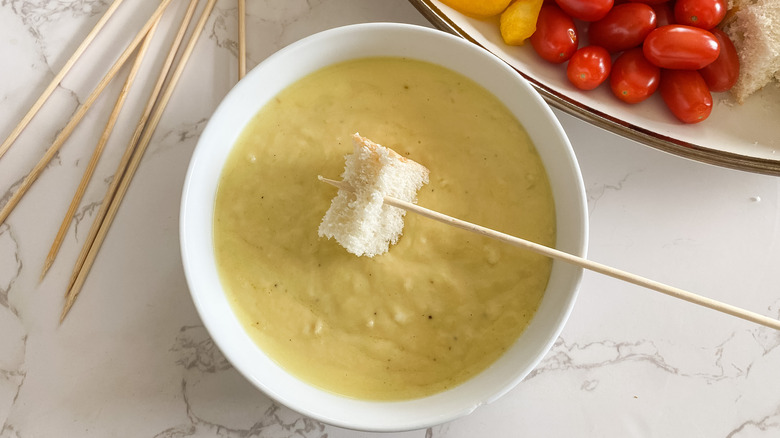 Dipping bread into fondue bowl