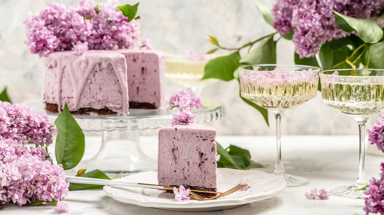 purple cake with fruit sliced on plate with drinks