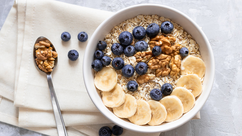 bowl of oatmeal topped with walnuts and blueberries