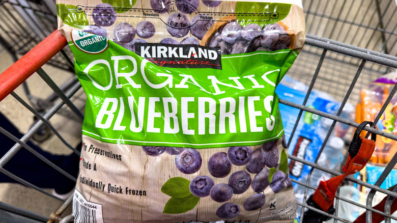A package of Kirkland Signature organic blueberries in a grocery cart